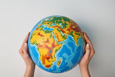 cropped view of woman holding globe on white background clipart