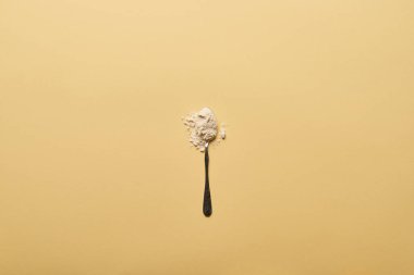 top view of spoon with scattered flour on yellow background clipart
