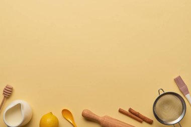 kopya alanı sarı zemin üzerine ekmek malzemeler ve mutfak aletleri üstten görünüm