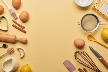 sarı zemin üzerine ekmek malzemeler ve mutfak eşyaları üstten görünüm