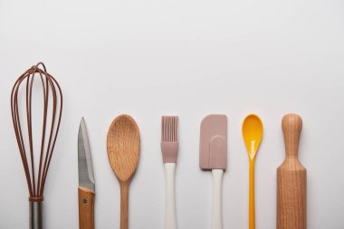 top view of cooking utensils arranged in row on grey background  clipart