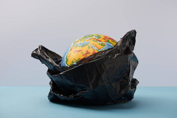 globe in black polyethylene bag on blue table and background