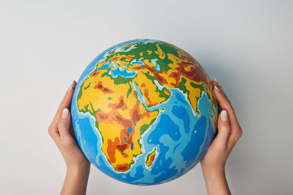 cropped view of woman holding globe on white background