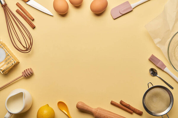 top view cooking utensils and ingredients frame on yellow background with copy space