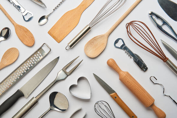 top view of metal and wooden cooking utensils on grey background 