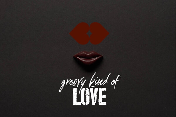 top view of tasty chocolate lips on black background with "groovy kind of love" lettering 