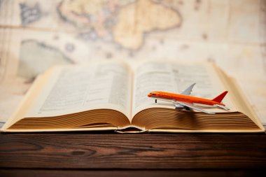 Seçici odak oyuncak uçak, kitap ve harita üzerinde ahşap masa