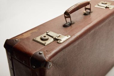 selective focus of vintage brown suitcase isolated on grey  clipart