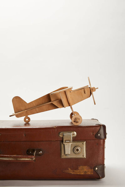 toy plane on brown leather suitcase with copy space 