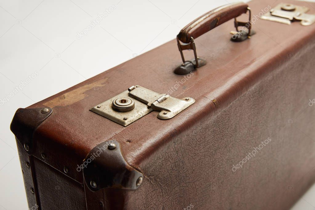 selective focus of vintage brown suitcase isolated on grey 