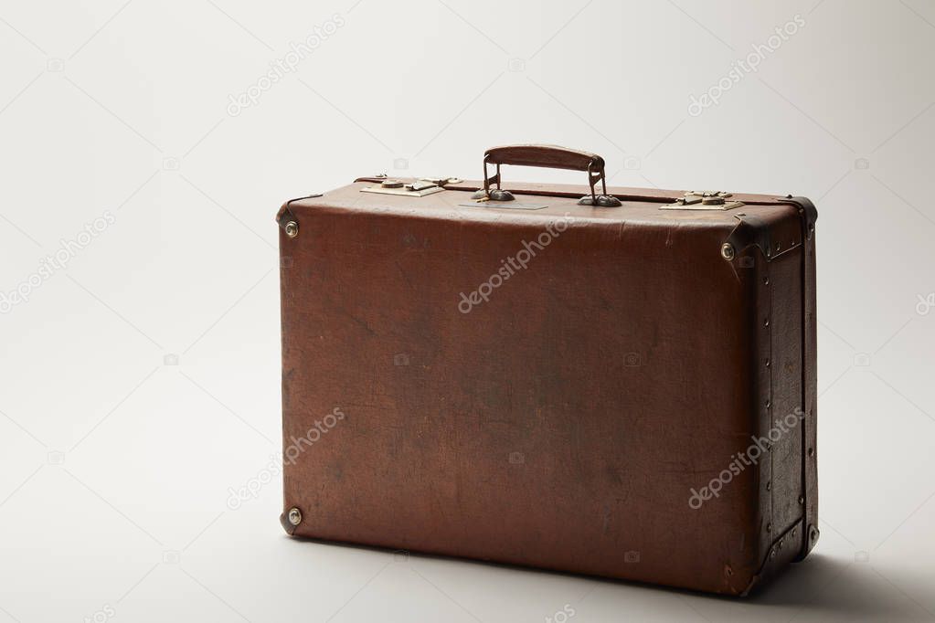 retro leather brown suitcase on grey background 