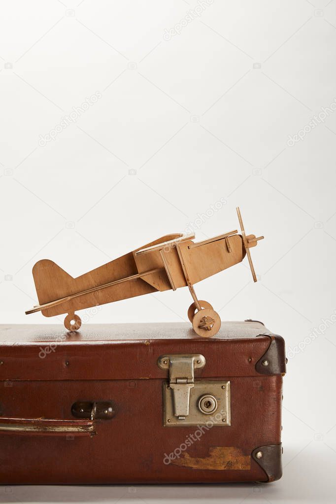 toy plane on brown leather suitcase with copy space 