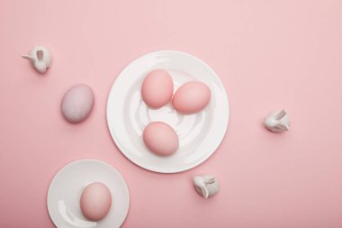 Üstten Görünüm oyuncak tavşanlar, uçan daire ve plaka üzerinde pembe bir arka plan üzerinde Paskalya yumurta