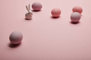 oyuncak tavşan ve pembe bir arka plan üzerinde boyalı Paskalya yumurtaları 