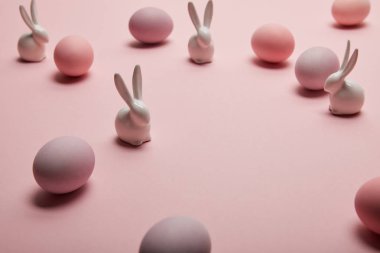 oyuncak tavşanlar ve pembe bir arka plan üzerinde boyalı Paskalya yumurtaları 