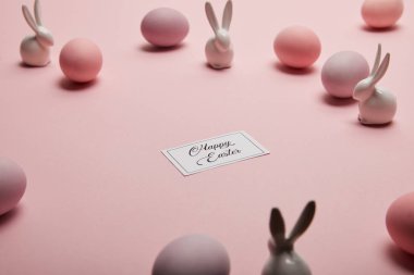 oyuncak tavşanlar, mutlu Paskalya yazı ve boyalı Paskalya yumurtaları kopya alanı ile pembe arka plan üzerinde kartı 
