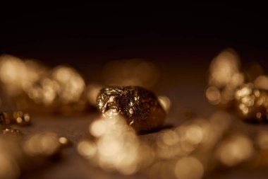 selective focus of golden stone on blurred dark background clipart