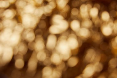 blurred bright twinkles and sparkles on golden background clipart