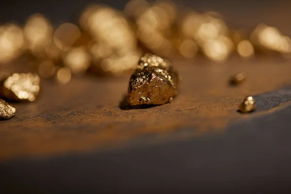 Selektiver Fokus Von Goldenen Steinen Auf Grauer Und Brauner Marmoroberfläche — Stockfoto