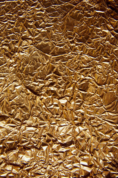 top view of rumpled sheet golden foil with glares