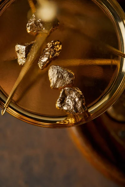 top view of golden stones on scales on marble background