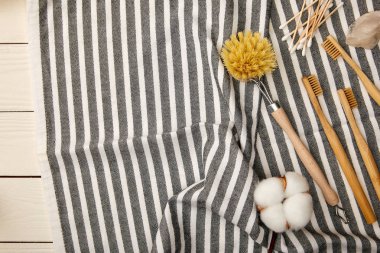 Hijyen ve bakım öğeleri üstten görünüm üzerinde beyaz ahşap yüzey, sıfır atık kavramı üzerinde çizgili havlu