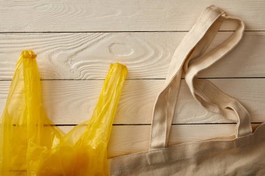 Beyaz ahşap yüzey, sıfır atık kavramı üzerinde pamuk dize torba ve poşet üstten görünüm