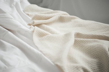 Close up of cozy empty bed with white blanket and sheets  clipart
