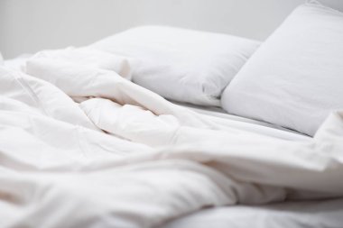 selective focus of bed with white pillows and blanket  clipart