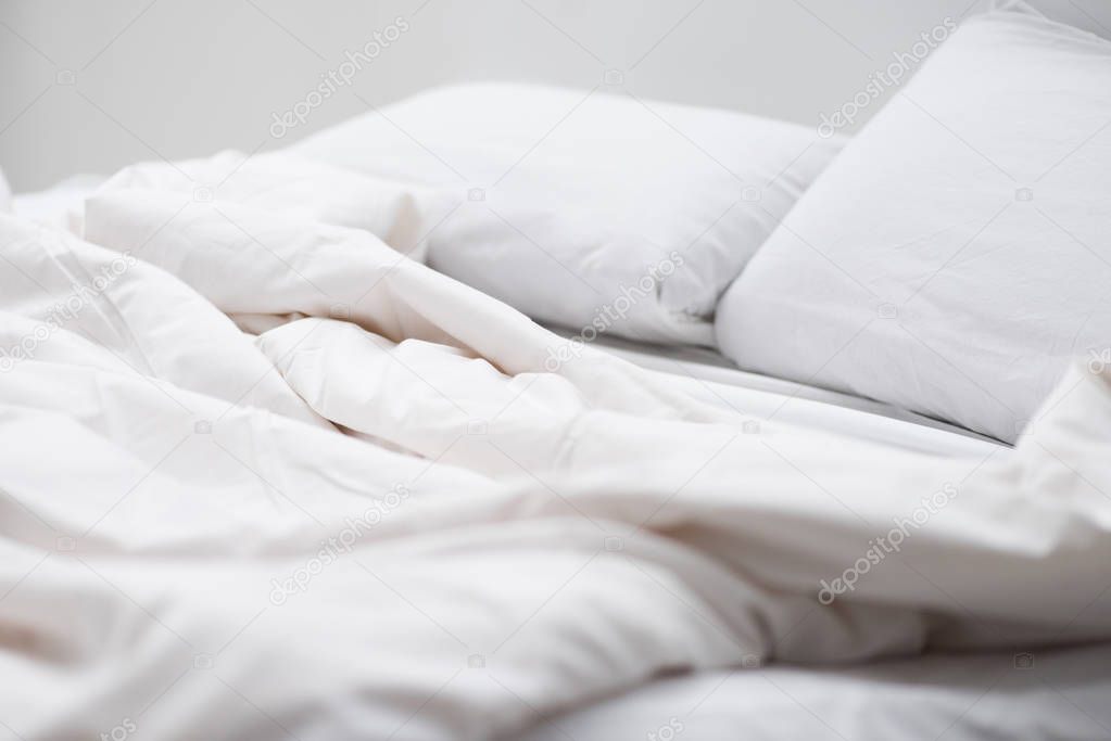 selective focus of bed with white pillows and blanket 