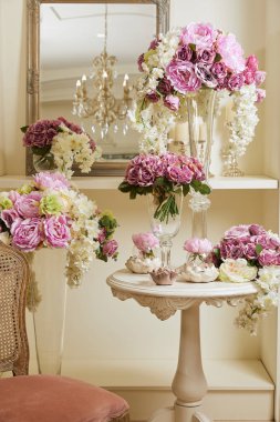 Oda sandalye, ayna, cam vazo çiçekleri ile iç