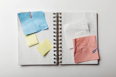açılan defter ile kare kağıtları ve yapışkan notlar üstten görünüm beyaz arka plan üzerinde