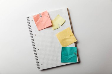 defter buruşuk yapışkan notlar yakınındaki boş kareleri alınmış sayfa ile üstten görünüm beyaz arka plan üzerinde