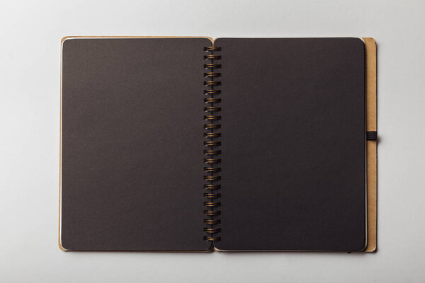 top view of black opened notebook on white background