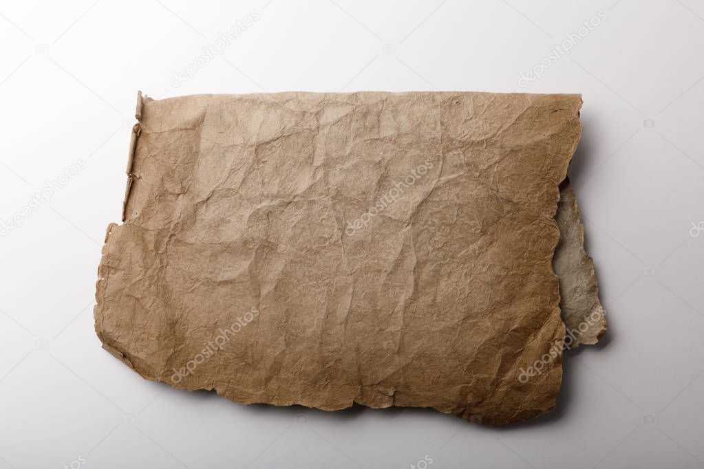 top view of old parchment paper lying on white background 