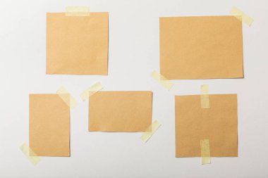 brown blank papers with sticky tape on white background clipart