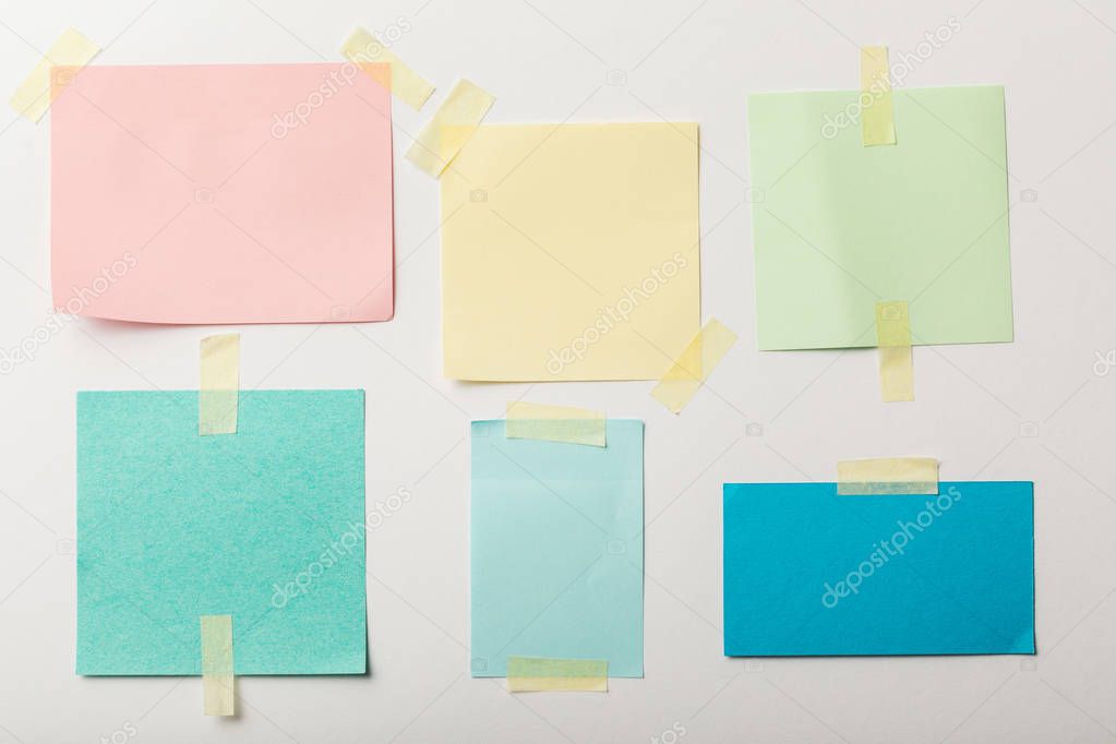 colorful blank papers with sticky tape on white background