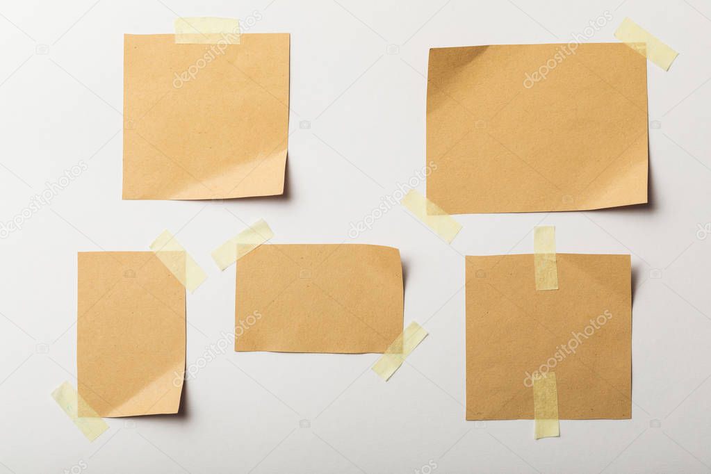 blank brown papers with sticky tape on white background