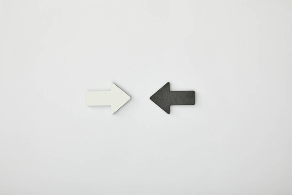 вид сверху белой стрелки напротив черного указателя на сером фоне
