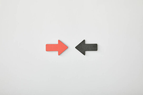 top view of red arrow opposite black pointer on grey background