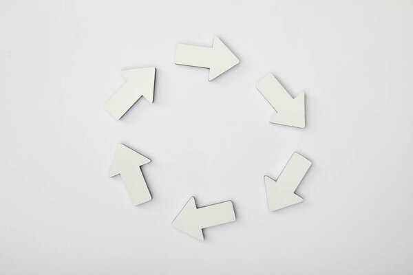 вид сверху белых стрелок по кругу на сером фоне
