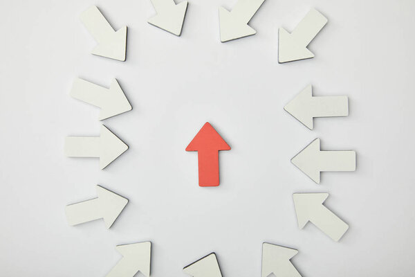 верхний вид красной стрелки в эллипсе с белыми указателями на сером фоне
