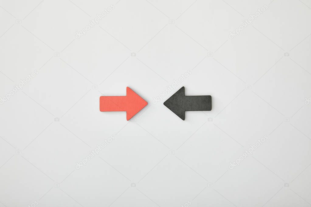 top view of red arrow opposite black pointer on grey background