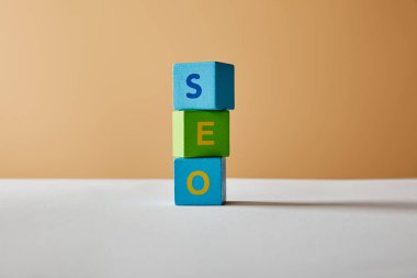 çok renkli bloklar beyaz masa ve bej renkli arka plan üzerinde dikey seo yazı yapılmış