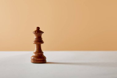 Beyaz masa ve bej renkli arka plan üzerinde ahşap Kraliçe parça