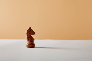 Beyaz masa ve bej renkli arka plan üzerinde ahşap şövalye parça