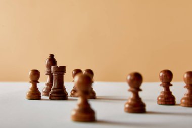 Beyaz masa ve bej renkli arka plan üzerinde ahşap satranç seçici odak