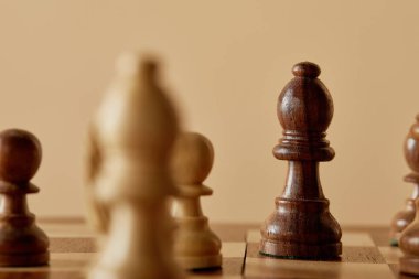 kahverengi satranç parça satranç tahtası ve bej arka plan üzerinde seçici odak