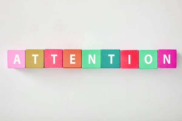 Top View Attention Lettering Made Multicolored Cubes Grey Background — Stock Photo, Image