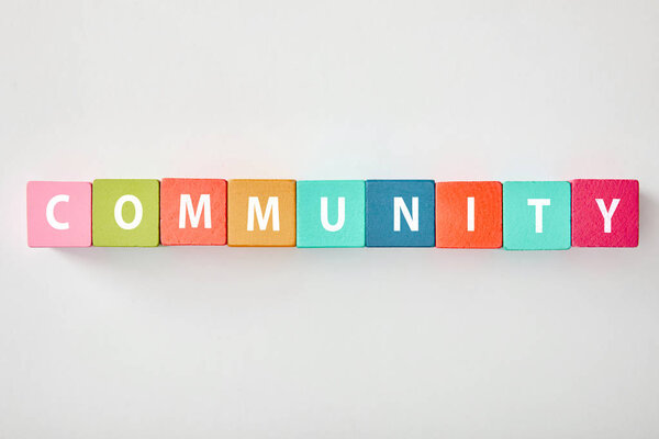 top view of community lettering made of multicolored cubes on grey background